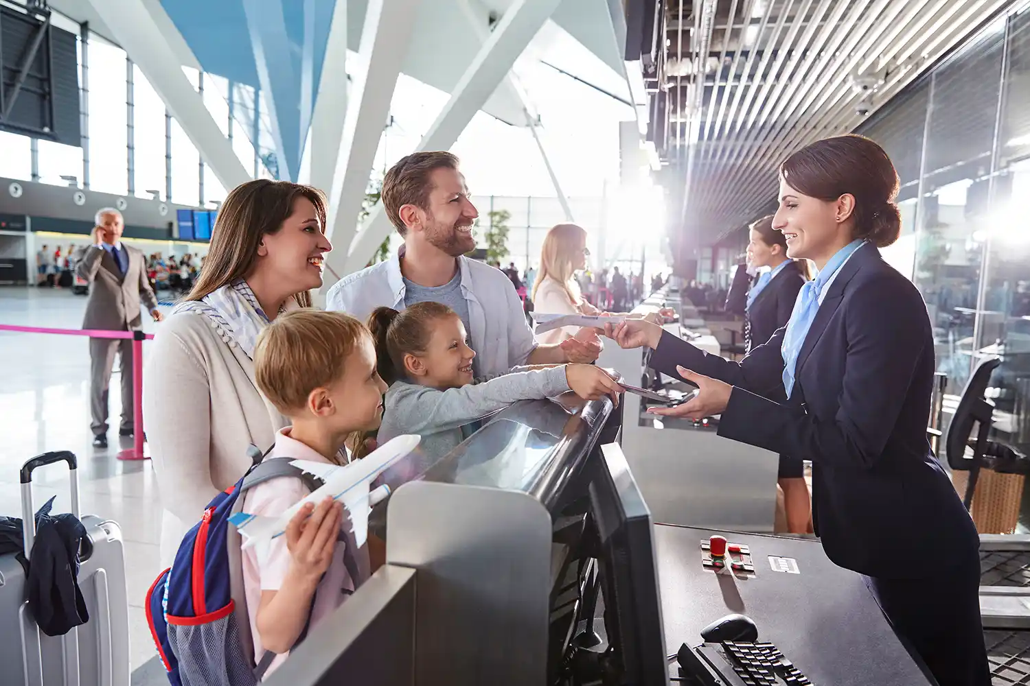Familie checkt nach einer Übernachtung im Hotel am Flughafen ein
