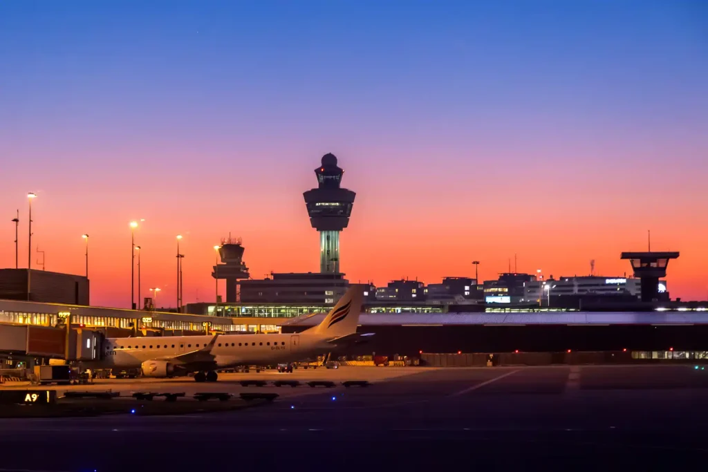 Flugzeuge Parken am Amsterdam Flughafen im Abendlicht mit Tower und Terminal